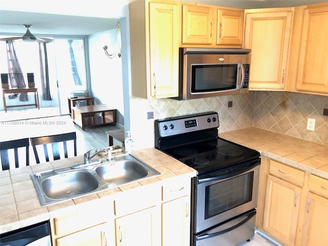 18900 NE 14th Ave Unit D204, Miami, FL 33179 - kitchen featuring appliances with stainless steel finishes, a sink, light brown cabinets, and tile counters