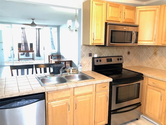 kitchen featuring light brown cabinets, sink, ceiling fan, decorative backsplash, and appliances with stainless steel finishes