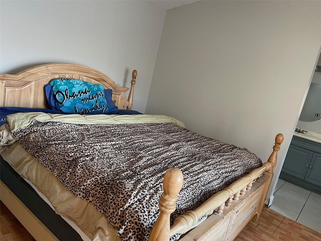 bedroom with tile patterned floors and ensuite bathroom