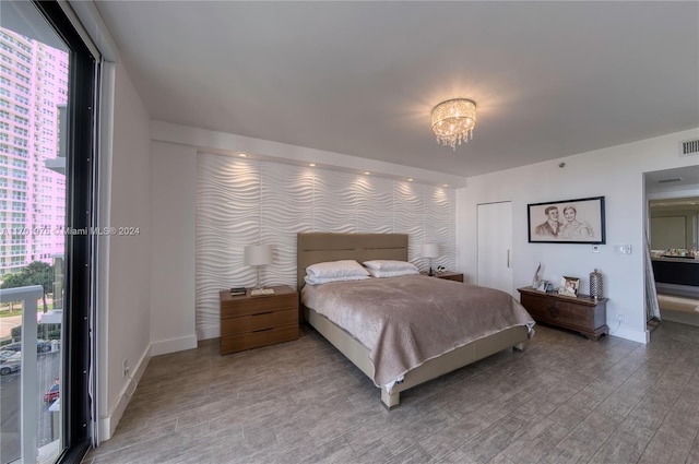 bedroom with hardwood / wood-style floors and an inviting chandelier