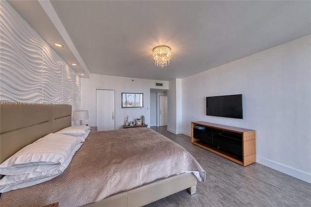 bedroom with wood-type flooring and a chandelier