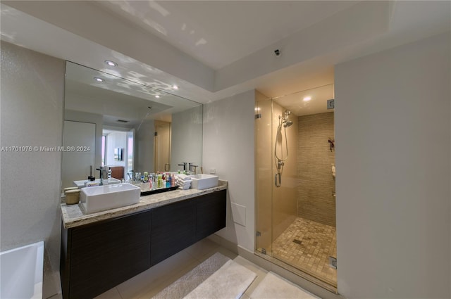 bathroom featuring tile patterned floors, a shower with door, and vanity