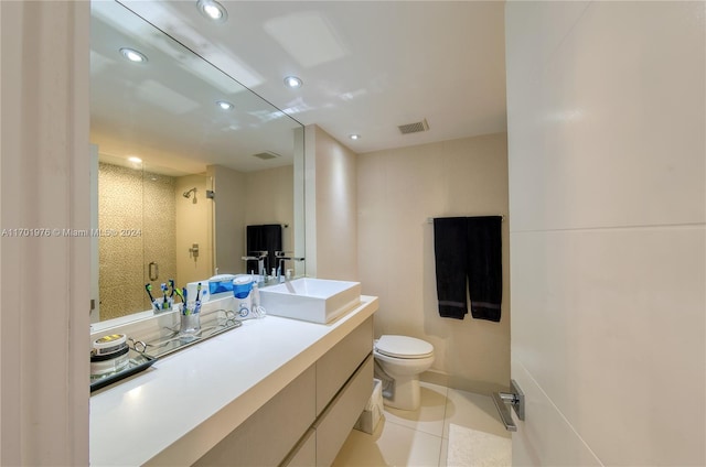 bathroom with toilet, vanity, tile patterned floors, and an enclosed shower