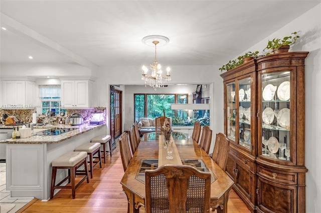 dining area featuring light hardwood / wood-style flooring and a notable chandelier