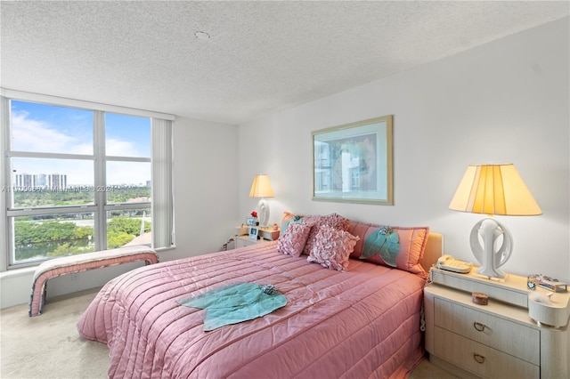 bedroom featuring a textured ceiling, carpet floors, and multiple windows