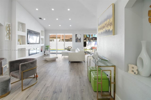 living room featuring light hardwood / wood-style flooring and vaulted ceiling