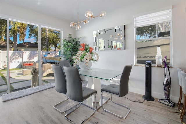 dining room featuring wood-type flooring and an inviting chandelier