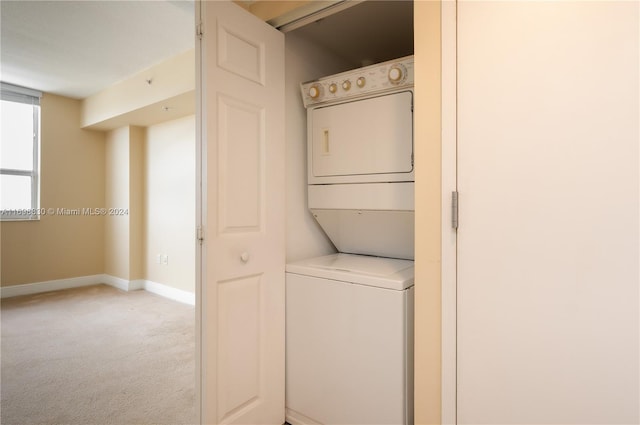 laundry room featuring stacked washing maching and dryer and light colored carpet