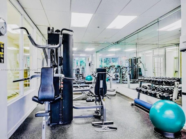 workout area featuring a paneled ceiling and plenty of natural light