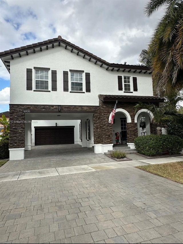 mediterranean / spanish home featuring covered porch and a garage