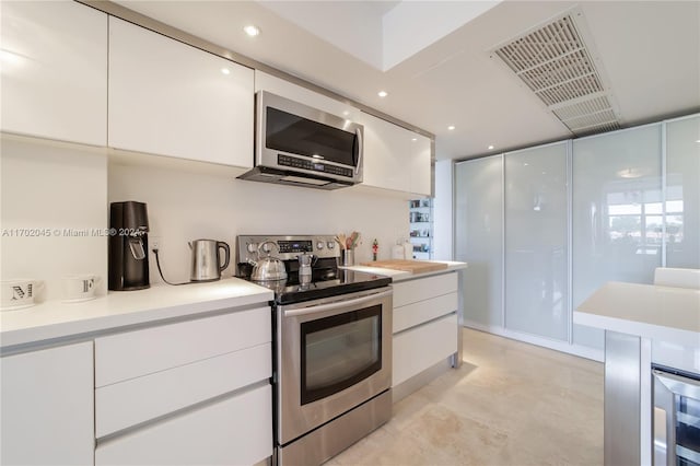 kitchen with wine cooler, stainless steel appliances, and white cabinetry