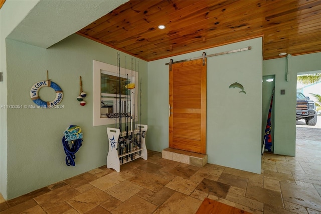 interior space featuring a barn door and wood ceiling