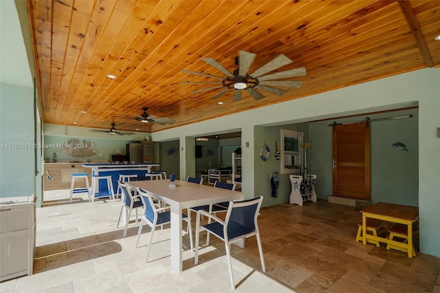 dining room with a barn door, wooden ceiling, and sink