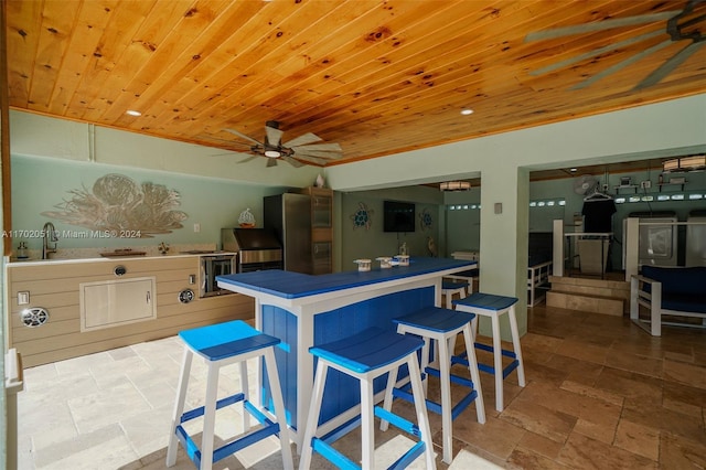 kitchen featuring sink, stainless steel refrigerator, ceiling fan, and wood ceiling