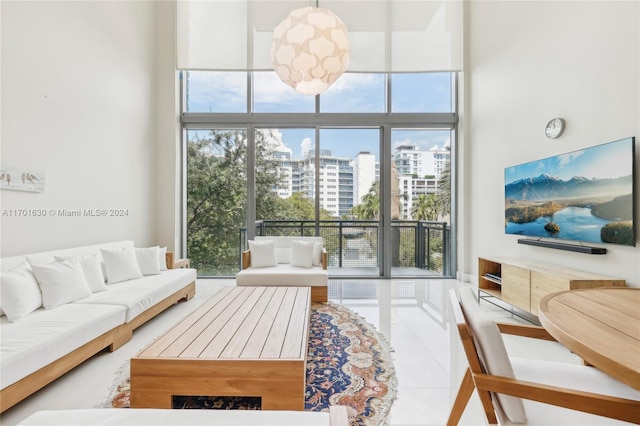 tiled living room featuring floor to ceiling windows and a towering ceiling