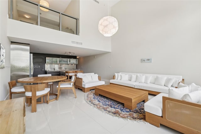 tiled living room featuring a towering ceiling