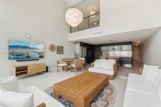 tiled living room featuring a towering ceiling