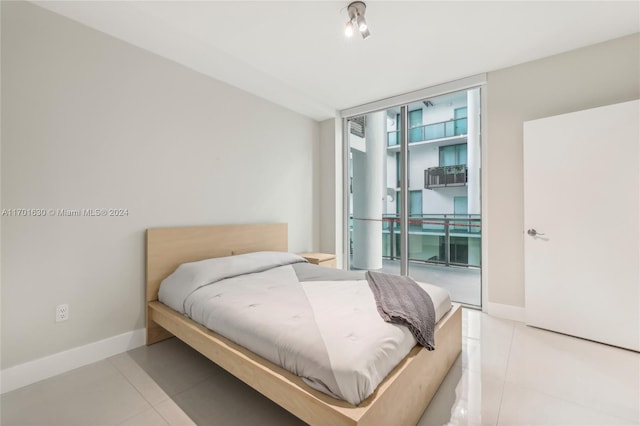 bedroom featuring expansive windows, light tile patterned floors, and access to outside