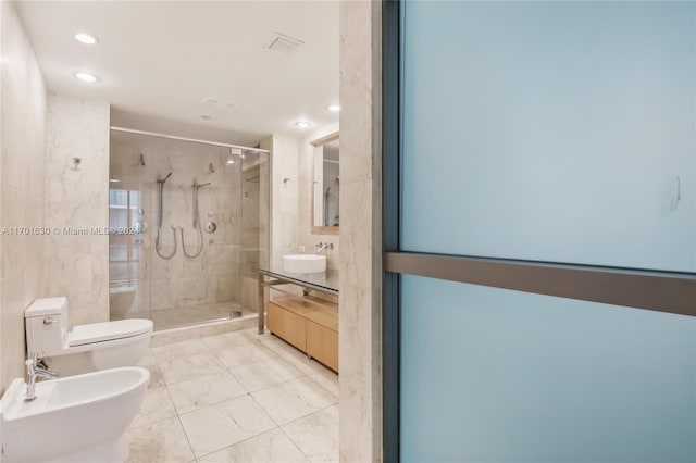 bathroom with vanity, toilet, a bidet, and a shower with shower door