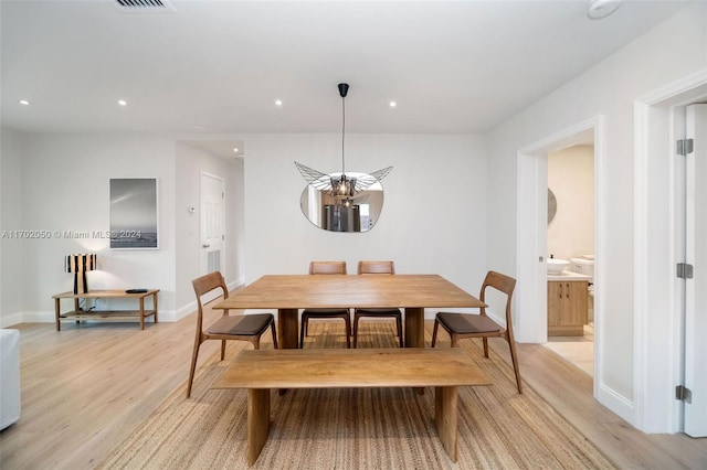 dining room featuring light wood-type flooring and a chandelier