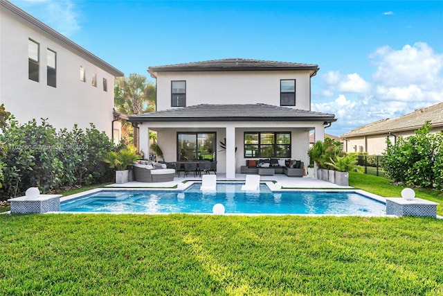 back of property with a lawn, outdoor lounge area, and a patio area