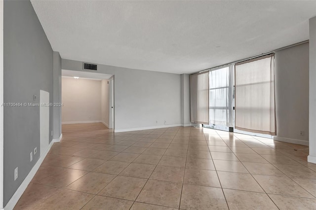 unfurnished room with light tile patterned flooring and a textured ceiling