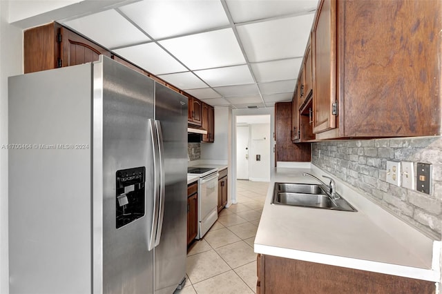 kitchen featuring stainless steel fridge, a paneled ceiling, electric stove, sink, and light tile patterned floors