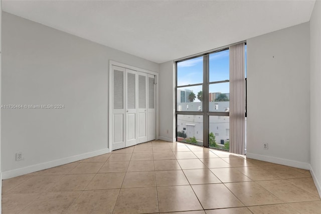 tiled empty room with a wall of windows