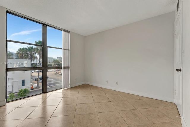 empty room featuring a textured ceiling and light tile patterned flooring