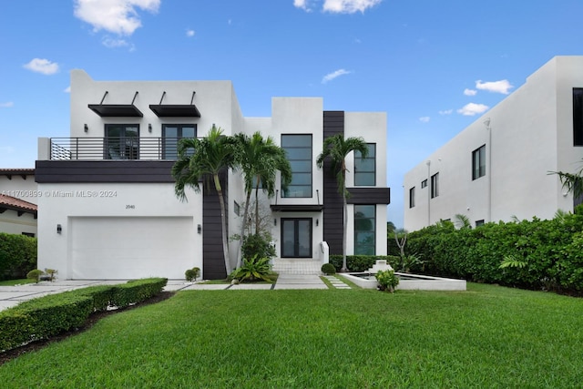 view of front of home with a balcony, a front lawn, and a garage