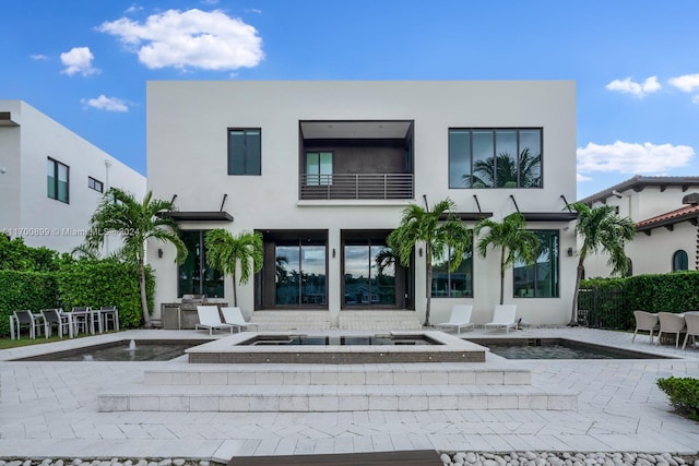 back of property featuring a balcony and a patio