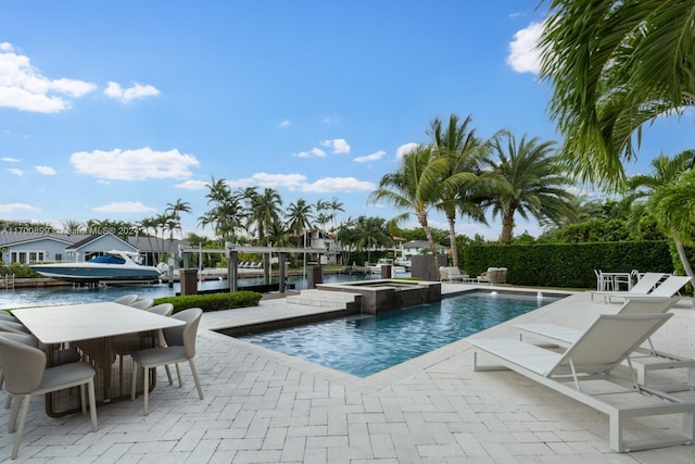 view of swimming pool featuring a patio area, an in ground hot tub, and a water view