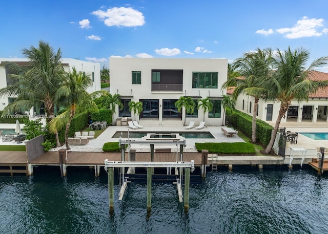 rear view of house with a patio and a water view