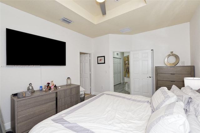 bedroom featuring a tray ceiling, ceiling fan, and hardwood / wood-style flooring