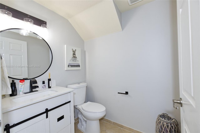 bathroom with toilet, vanity, tile patterned floors, and lofted ceiling