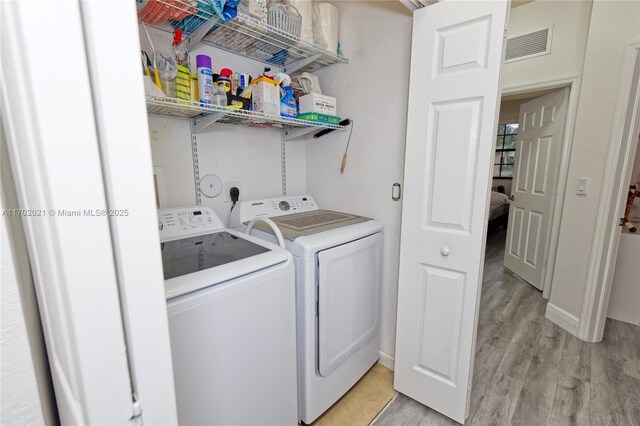 laundry room featuring light hardwood / wood-style flooring and independent washer and dryer