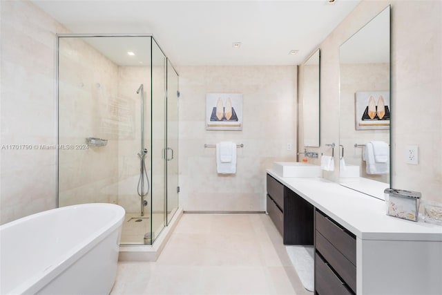 bathroom featuring tile patterned floors, vanity, independent shower and bath, and tile walls