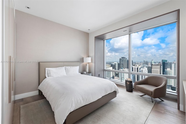 bedroom with hardwood / wood-style floors and multiple windows