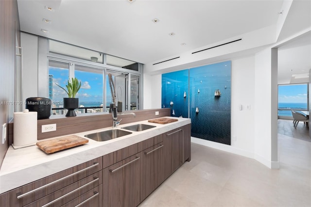 kitchen featuring sink, a water view, and dark brown cabinets