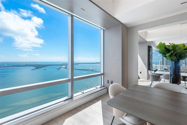 dining room featuring a water view and light hardwood / wood-style flooring