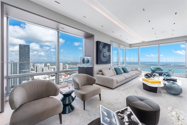 living room with plenty of natural light, a water view, and light colored carpet