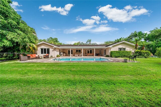 rear view of house with an outdoor hangout area, a patio area, and a lawn