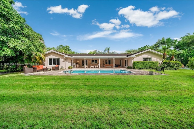 rear view of house with a patio, an outdoor hangout area, an outdoor pool, a yard, and stucco siding