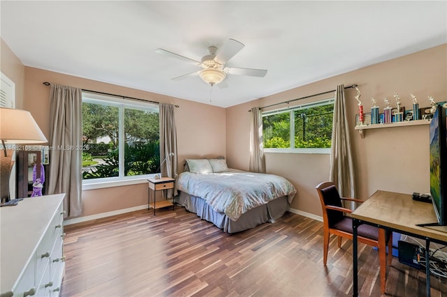 bedroom featuring a ceiling fan, baseboards, and wood finished floors