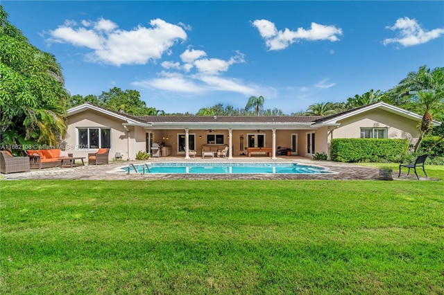 back of property with stucco siding, outdoor lounge area, a lawn, a ceiling fan, and an outdoor pool