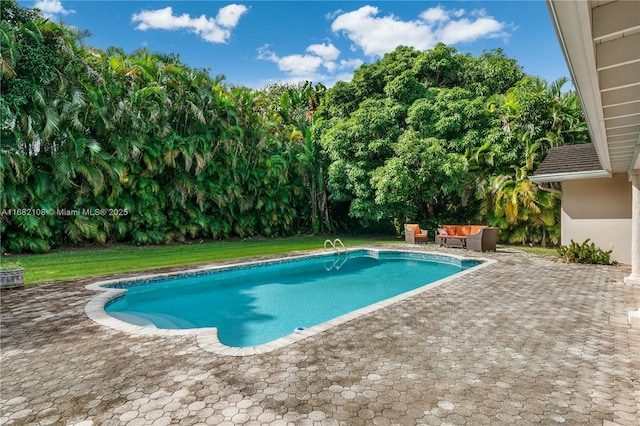 outdoor pool with a patio area, a yard, and an outdoor hangout area