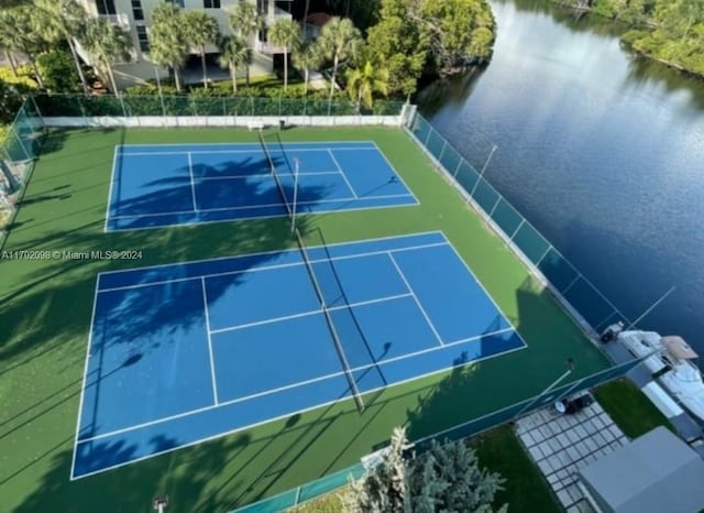 view of tennis court featuring a water view