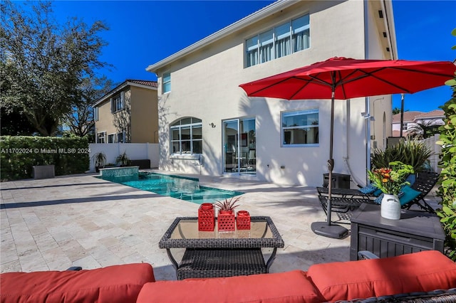 back of property featuring a patio and a fenced in pool