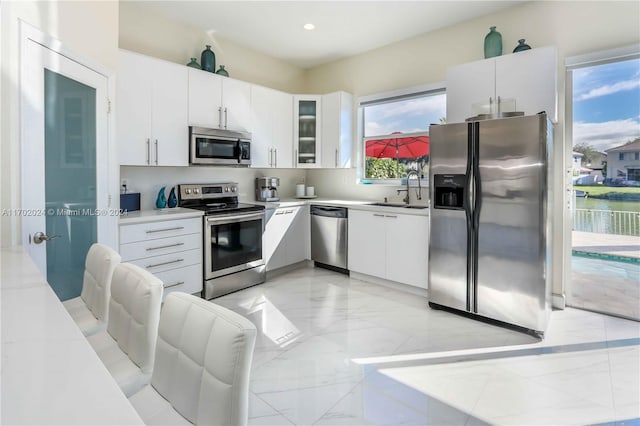 kitchen featuring white cabinetry, sink, and appliances with stainless steel finishes