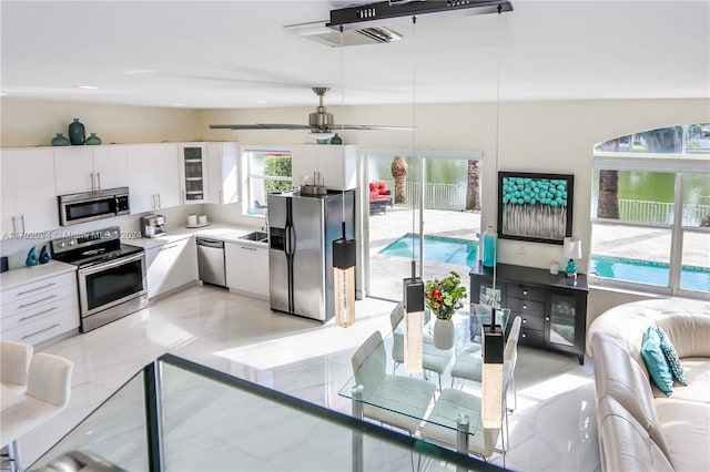 kitchen featuring stainless steel appliances, white cabinetry, ceiling fan, and lofted ceiling